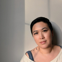 Asian American woman with short black hair, wearing a white t shirt