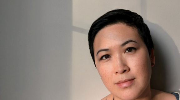 Asian American woman with short black hair, wearing a white t shirt